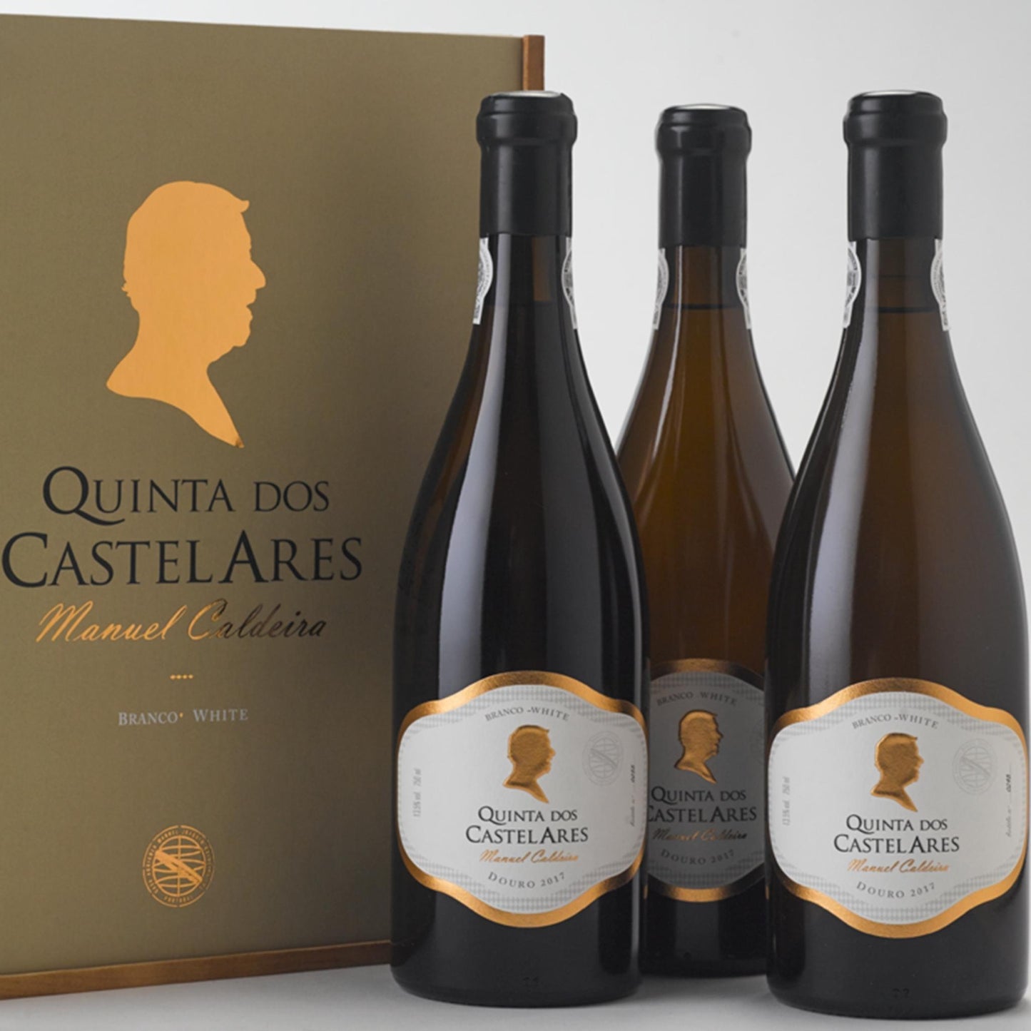 
                  
                    Quinta dos Castelares Manuel Caldeira, Weißwein aus dem Douro, Portugal. Drei Weinflaschen vor einer Wein-Holzkiste stehend.
                  
                