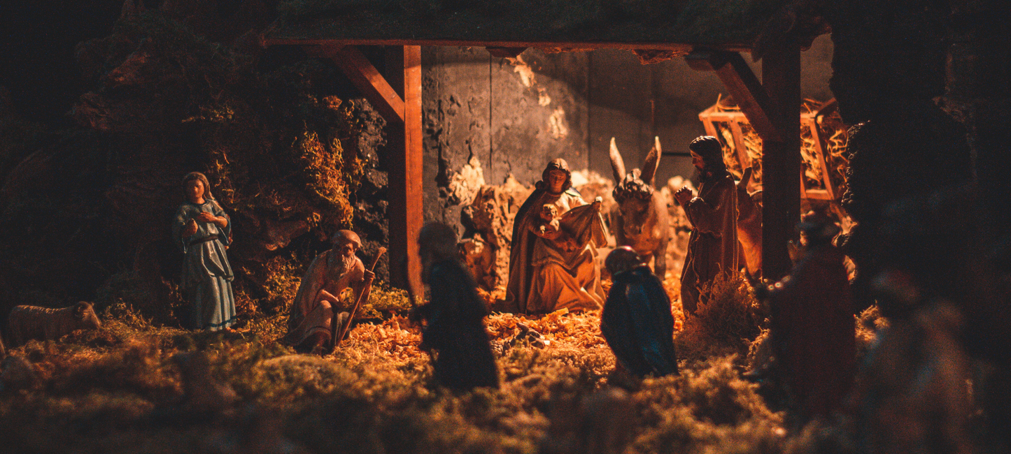 Auf dem Bild ist eine Szene aus einer Weihnachtskrippe zu sehen. Figuren sind in einem Stall aufgebaut.