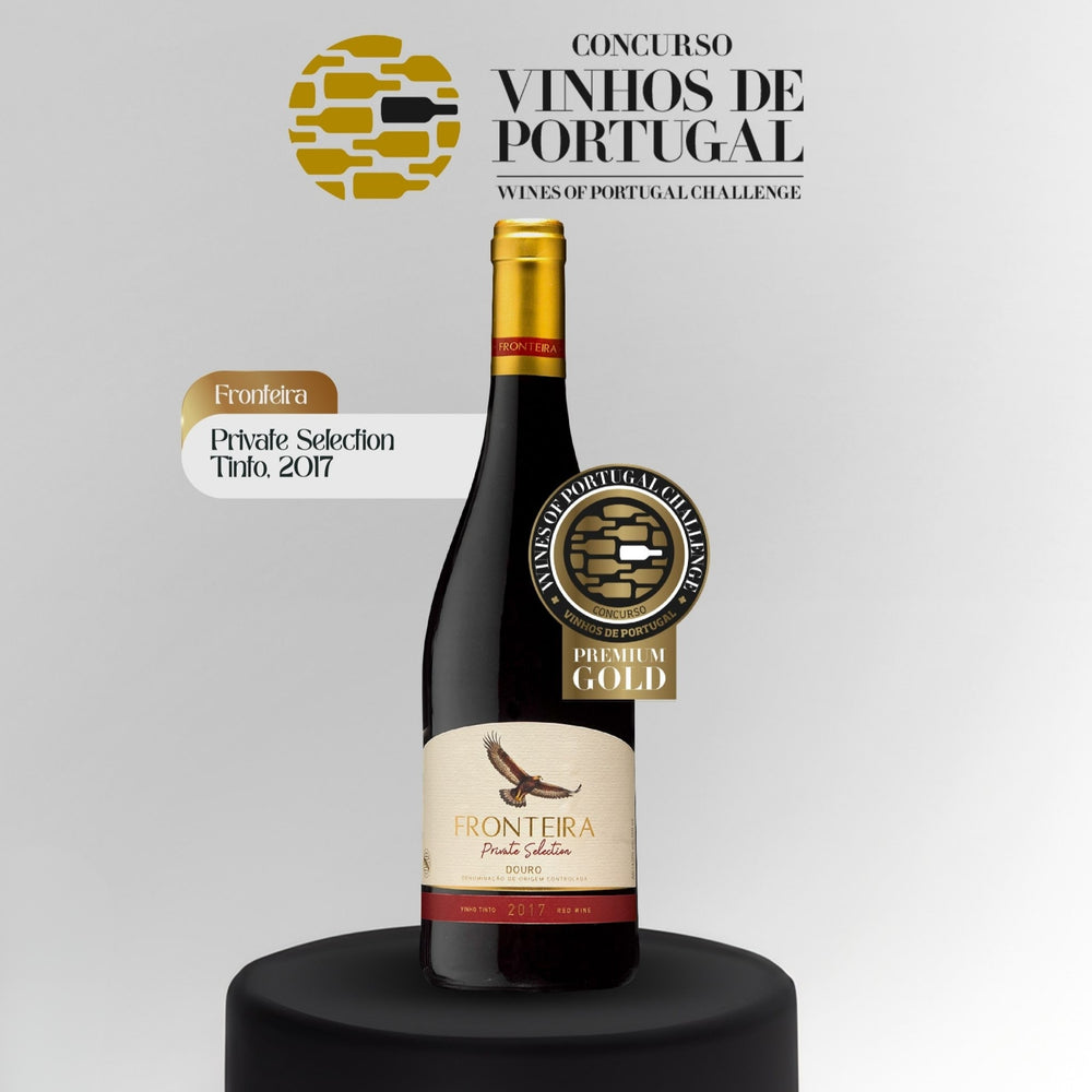 
                  
                    Flasche Fronteira Private Selection Rotwein (Vinho Tinto) aus dem Douro-Gebiet, Jahrgang 2017. Der Wein ist tiefdunkelrot/violett. Das helle Etikett zeigt einen fliegenden Adler in Braun-Goldtönen. Der Schriftzug lautet „FRONTEIRA Private Selection DOURO“. Die untere Kante des Etiketts ist rot und zeigt den Jahrgang 2017. Die Flasche hat einen goldenen Schraubverschluss.
                  
                