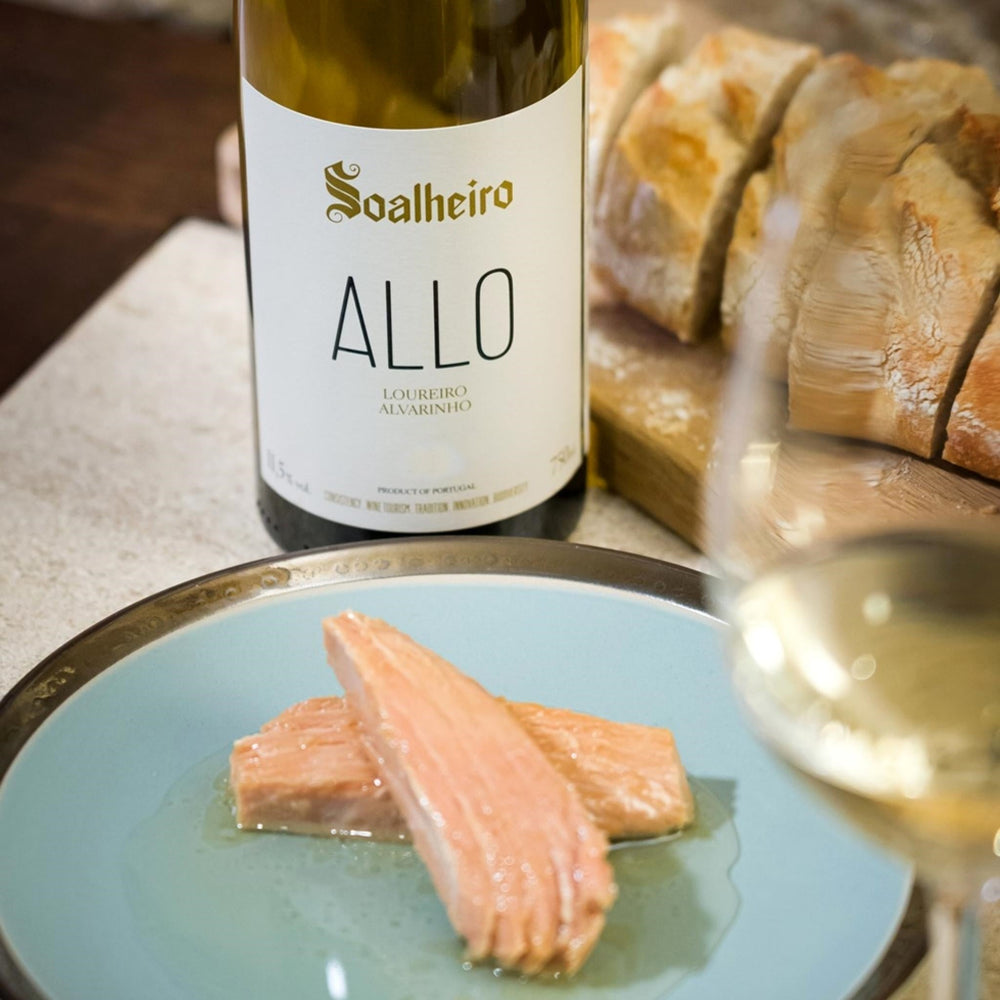 
                  
                    Soalheiro Allo, Vinho Verde vom Weingut Soalheiro aus der Region Minho / Portugal. Flasche auf einem Tisch stehend mit gedünstetem und Weißbrot.
                  
                