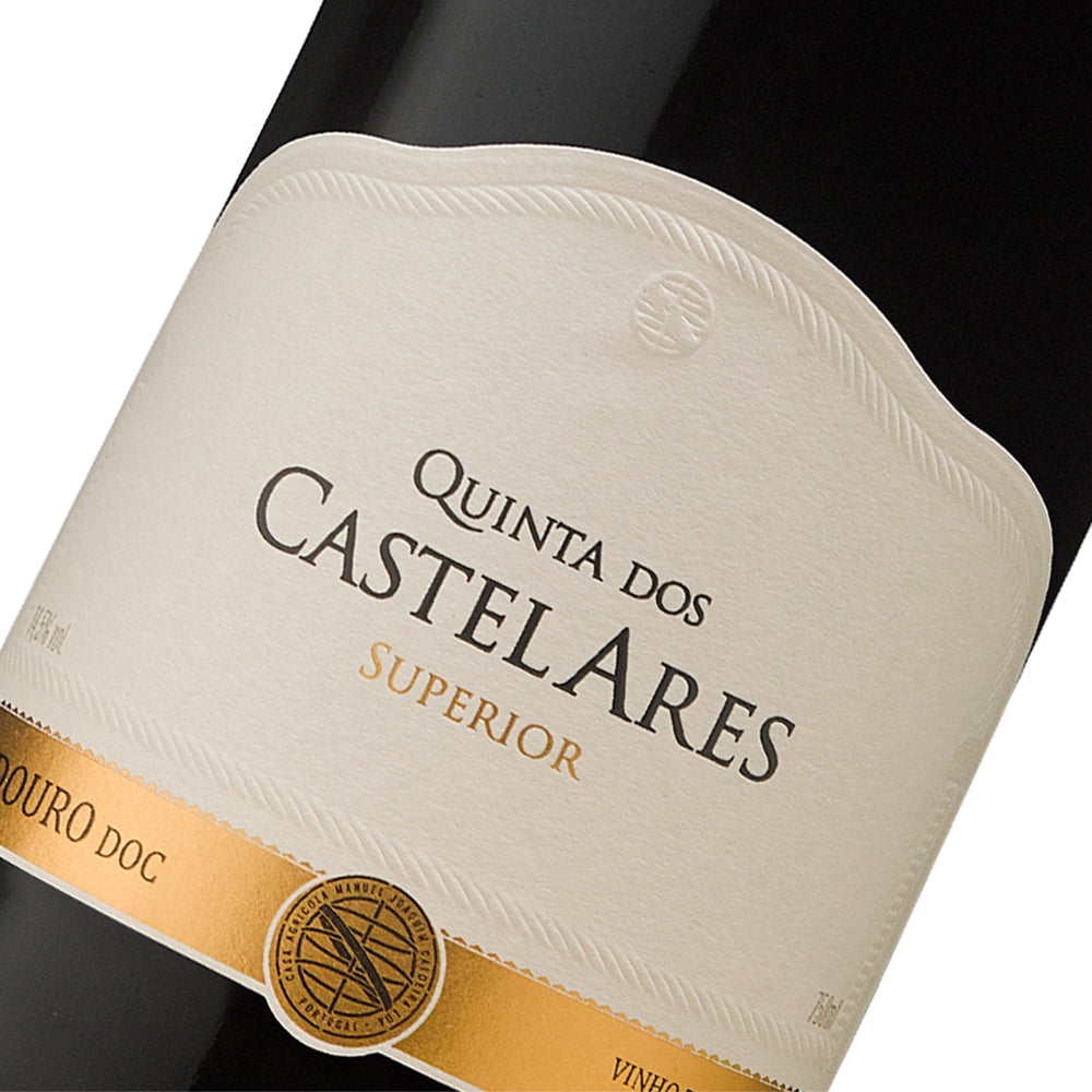 
                  
                    Flasche Quinta dos Castelares Superior Rotwein (Vinho Tinto) aus dem Douro DOC-Gebiet. Der Wein ist sehr dunkel, fast undurchsichtig. Das breite Etikett ist cremefarben/weiß und trägt den Schriftzug „QUINTA DOS CASTELARES SUPERIOR“. Am unteren Rand befindet sich eine goldene, dekorative Leiste mit einem runden Emblem. Die Flasche hat einen schwarzen Verschluss und eine goldene Banderole mit dem Namen „Quinta dos Castelares“ am Flaschenhals.
                  
                