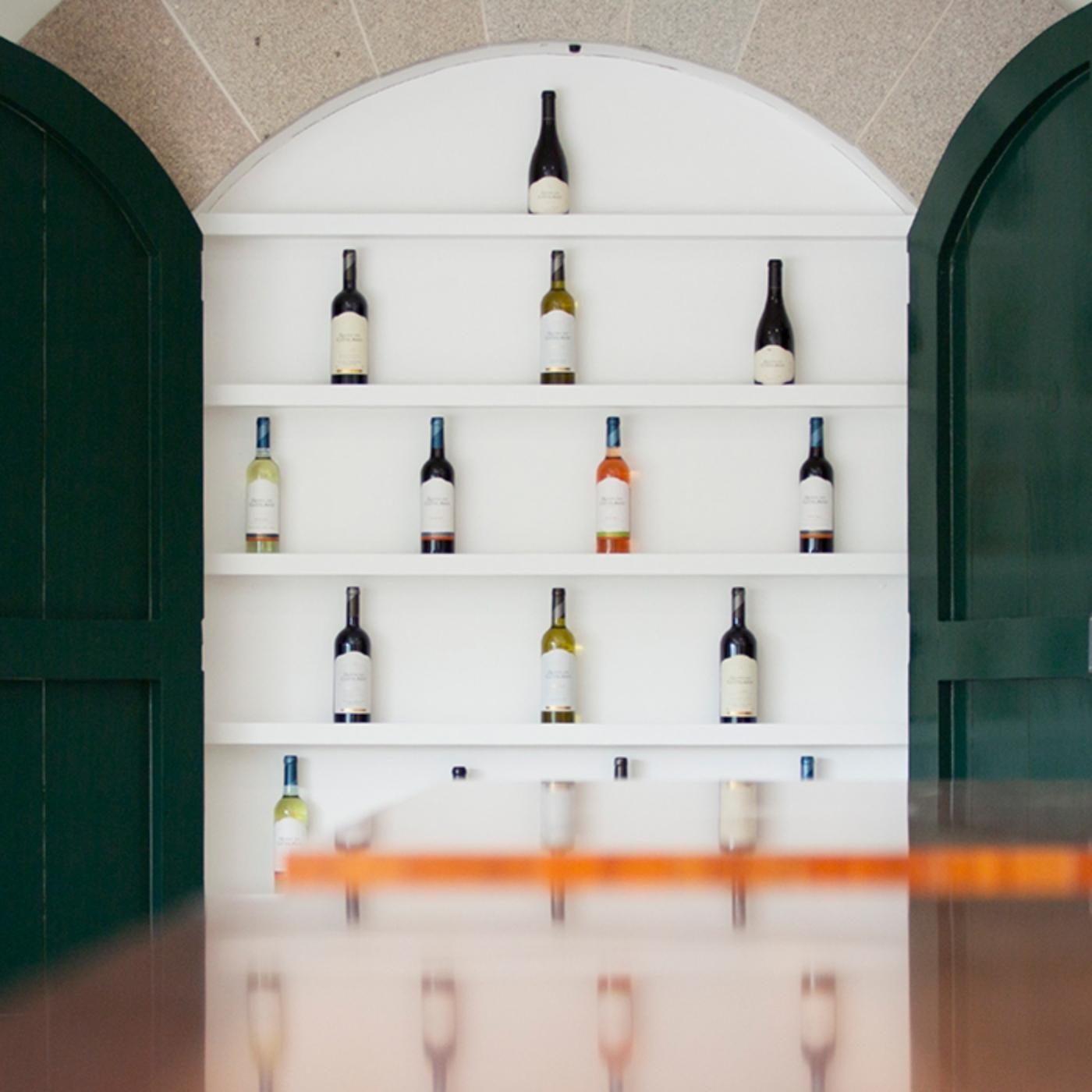 Bild von den Innenräumen der Quinta dos Castelares. Blick in eine Art geöffneten Weinschrank, eine Präsentation der Weine mit viel Flaschen im Regal stehend.